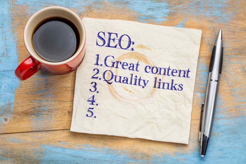 SEO (search engine optimization) tips (great content and quality links) on napkin with a cup of coffee